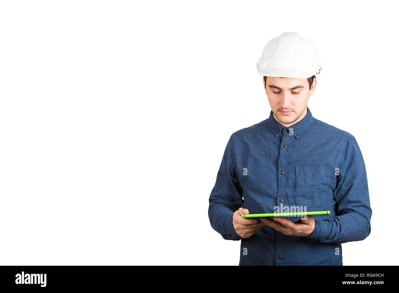 Confident young man engineer wearing protective helmet using a tablet ...