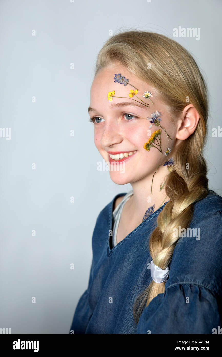 Portrait of smiling blond girl with tattoo of pressed flowers on her