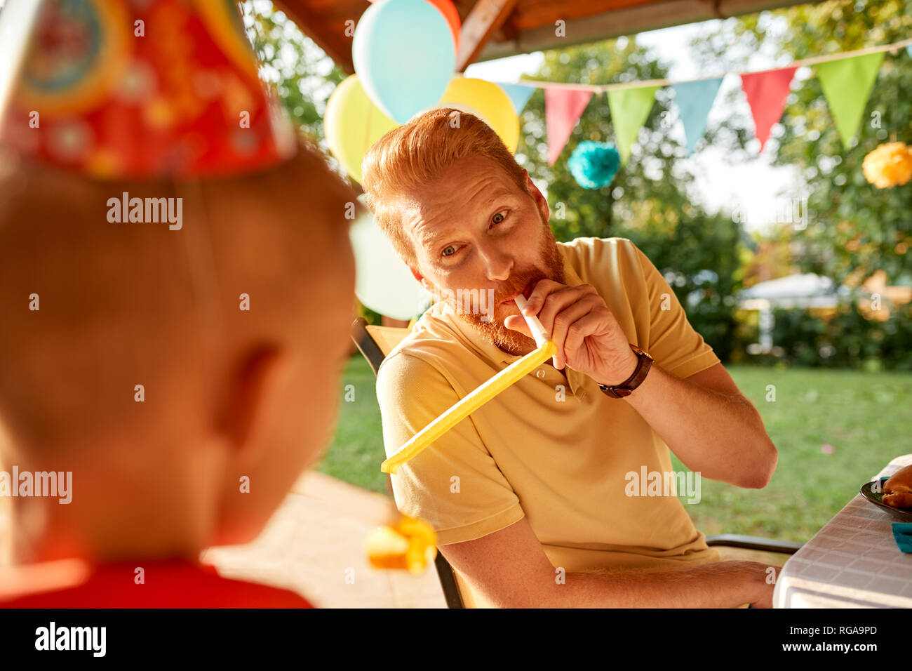 Playful father with son on a garden birthday party Stock Photo