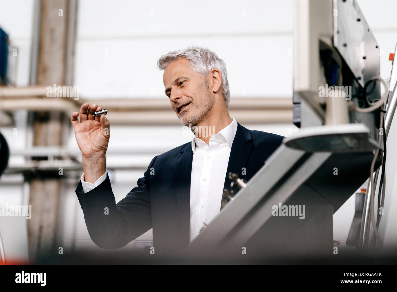 Manager in high tech enterprise, checking machine parts Stock Photo Alamy