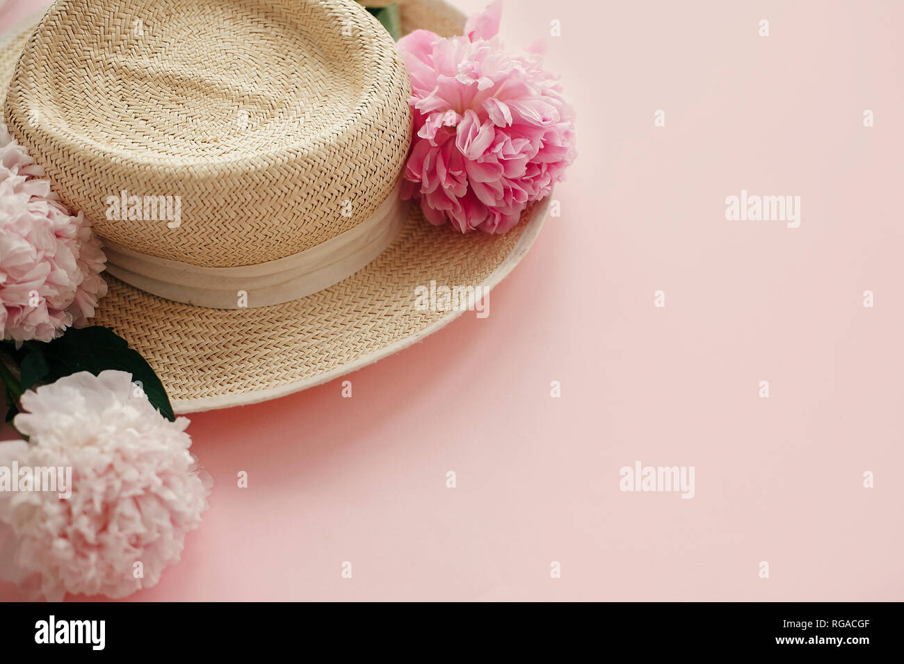 Straw hat with white and pink peonies on pastel pink paper. Hello ...