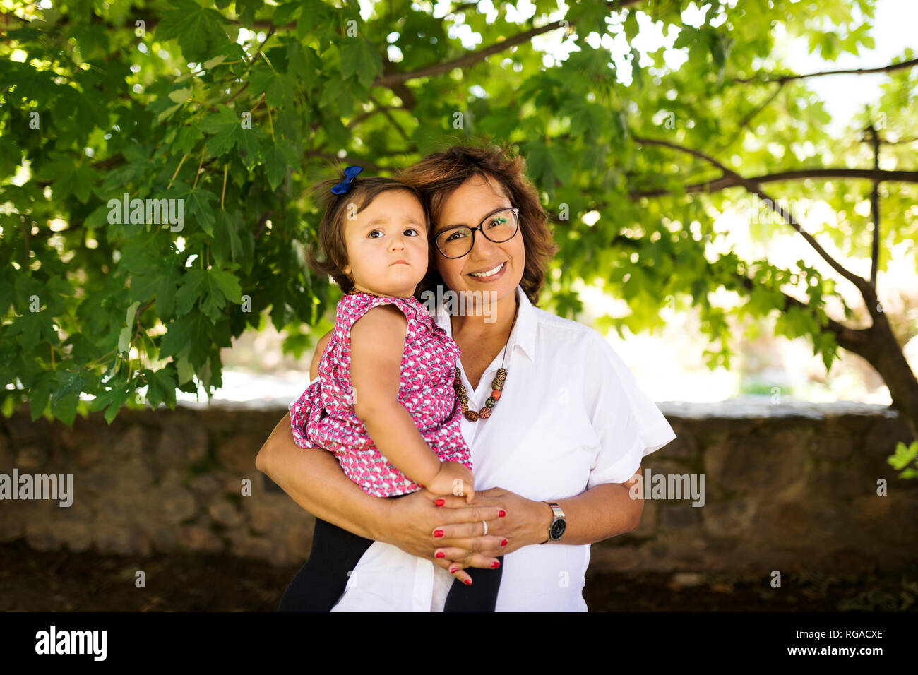 Portrait of smiling mature woman with baby girl Stock Photo