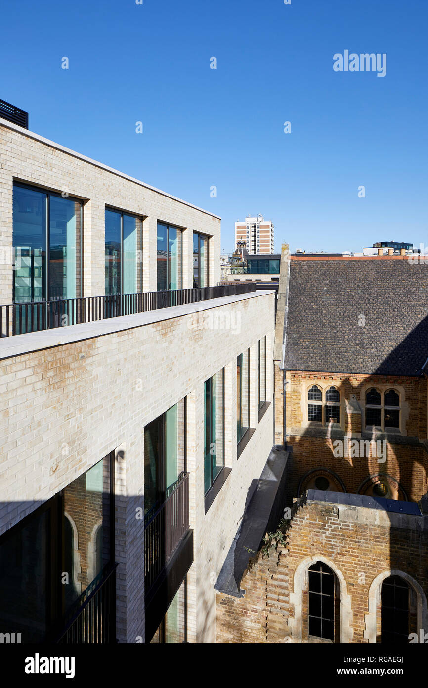 Juxtaposition of historic church and new office facade. Paul Street, London, United Kingdom. Architect: Stiff + Trevillion Architects, 2018. Stock Photo