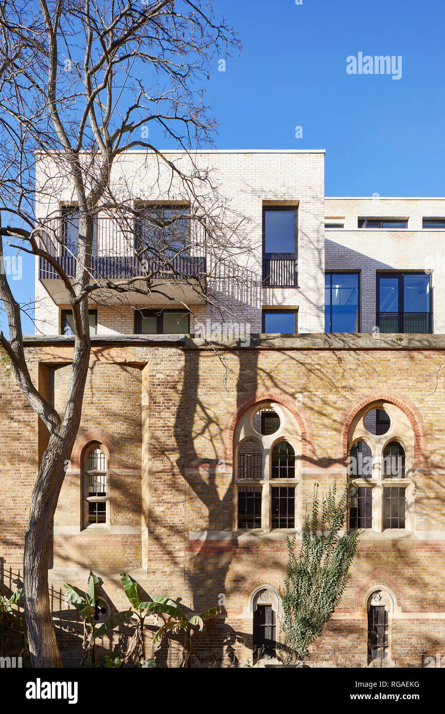 Juxtaposition of historic church and new office facade. Paul Street, London, United Kingdom. Architect: Stiff + Trevillion Architects, 2018. Stock Photo