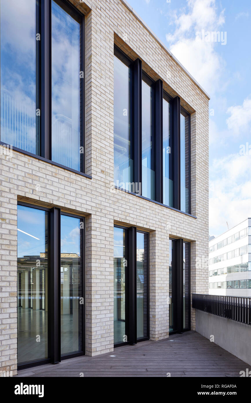 Oblique view of brick and window facade on rooftop. Paul Street, London, United Kingdom. Architect: Stiff + Trevillion Architects, 2018. Stock Photo