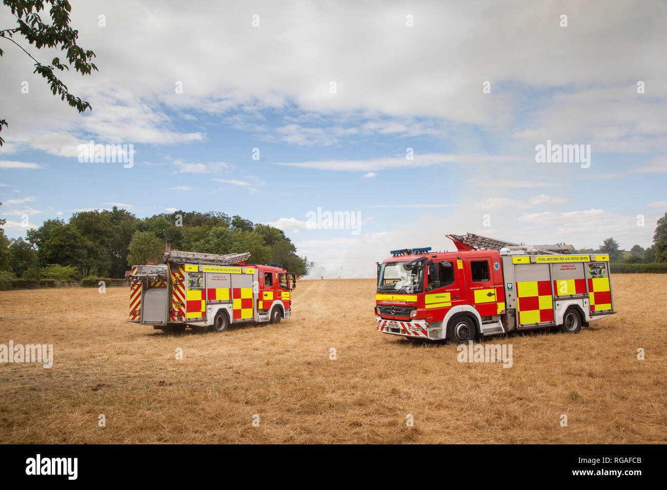 Firemen and appliances from Royal Berkshire Fire and Rescue Service attend a stubble fire near Kidmore End, Oxfordshire Stock Photo