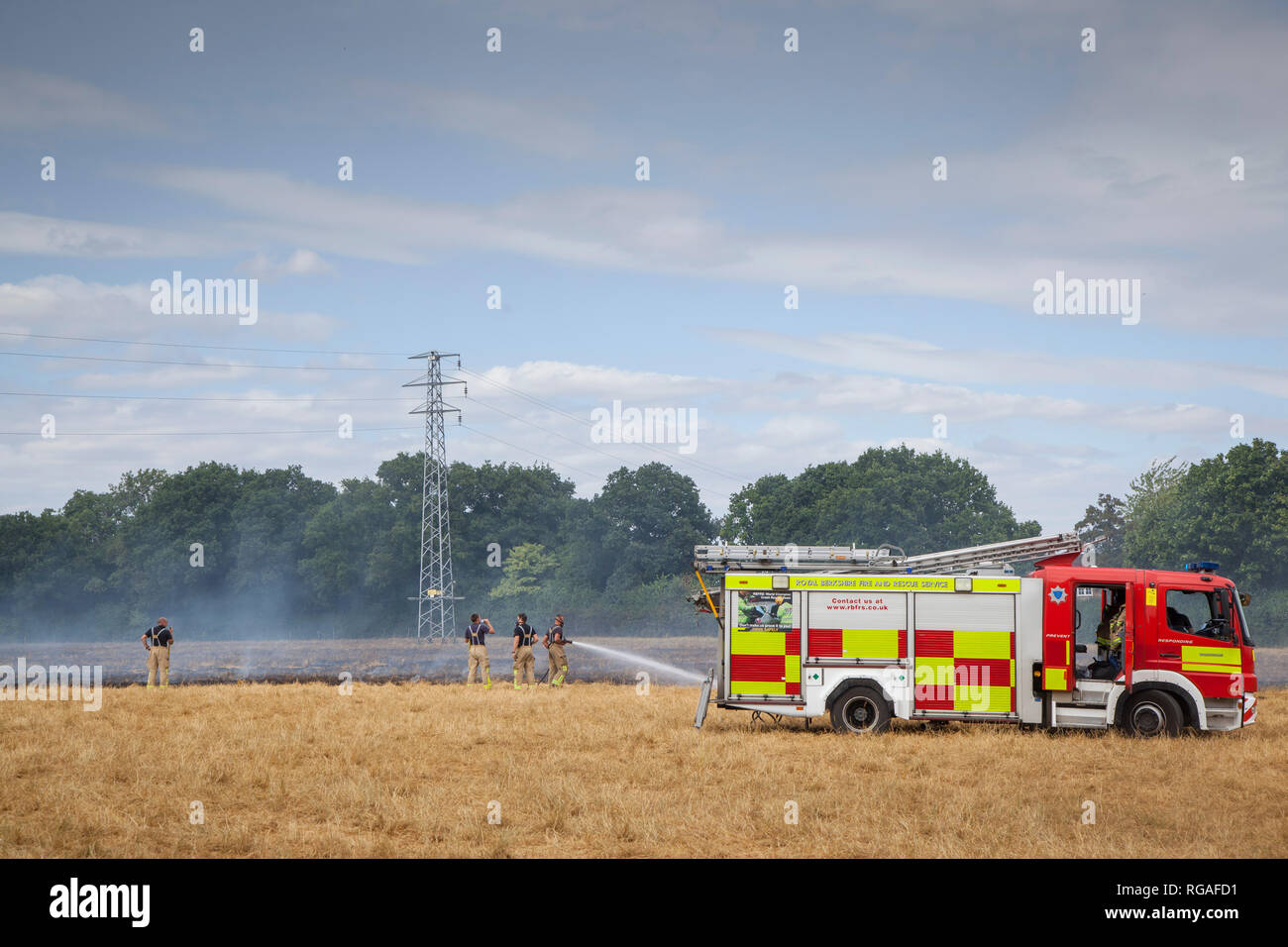 Firemen and appliances from Royal Berkshire Fire and Rescue Service attend a stubble fire near Kidmore End, Oxfordshire Stock Photo