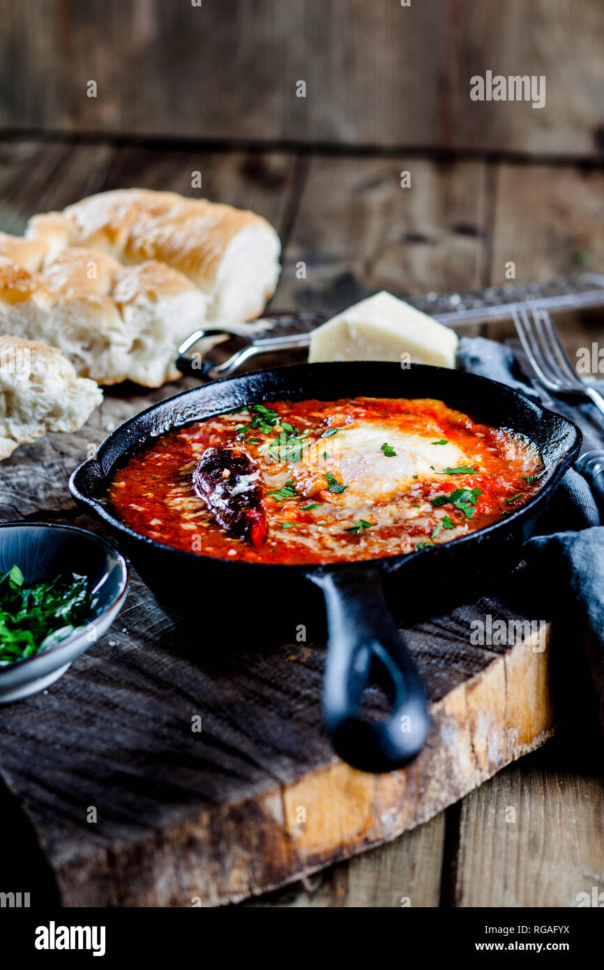 Eggs in Purgatory, eggs, baked in very spicy tomato sauce, sprinkled with parsley and parmegiano Stock Photo
