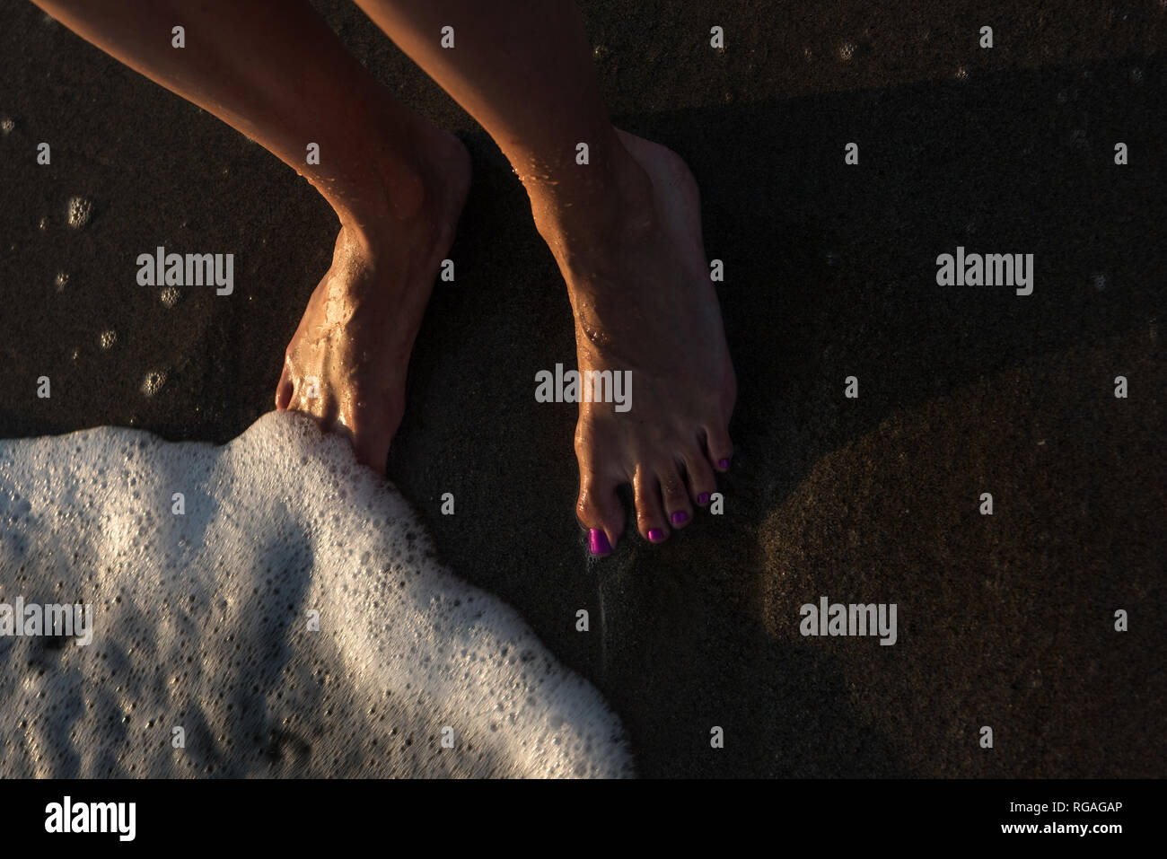 Feet washed by sea waves Stock Photo