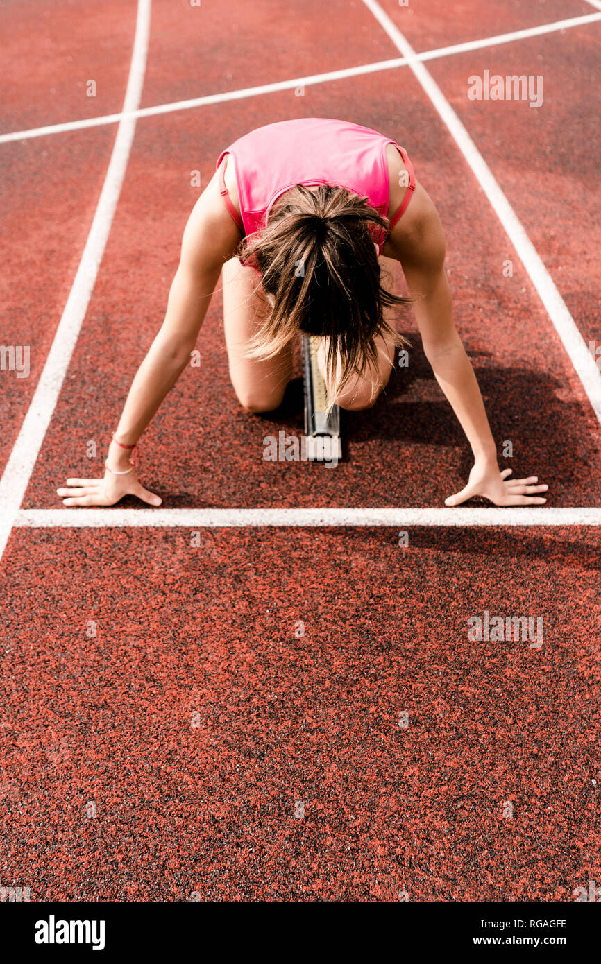 Teenage runner in starting position on race track Stock Photo Alamy
