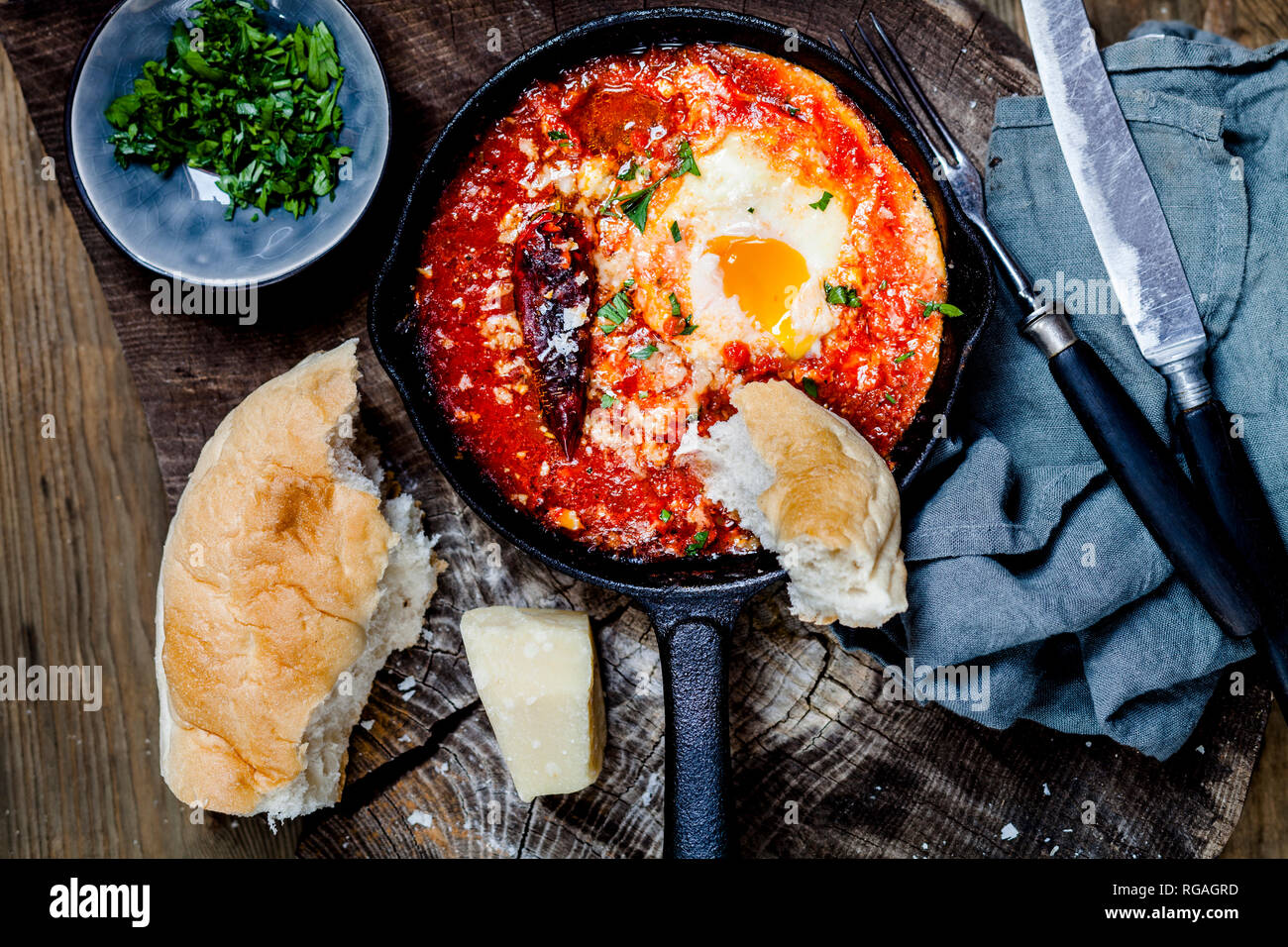 Eggs in Purgatory, eggs, baked in very spicy tomato sauce, sprinkled with parsley and parmegiano Stock Photo