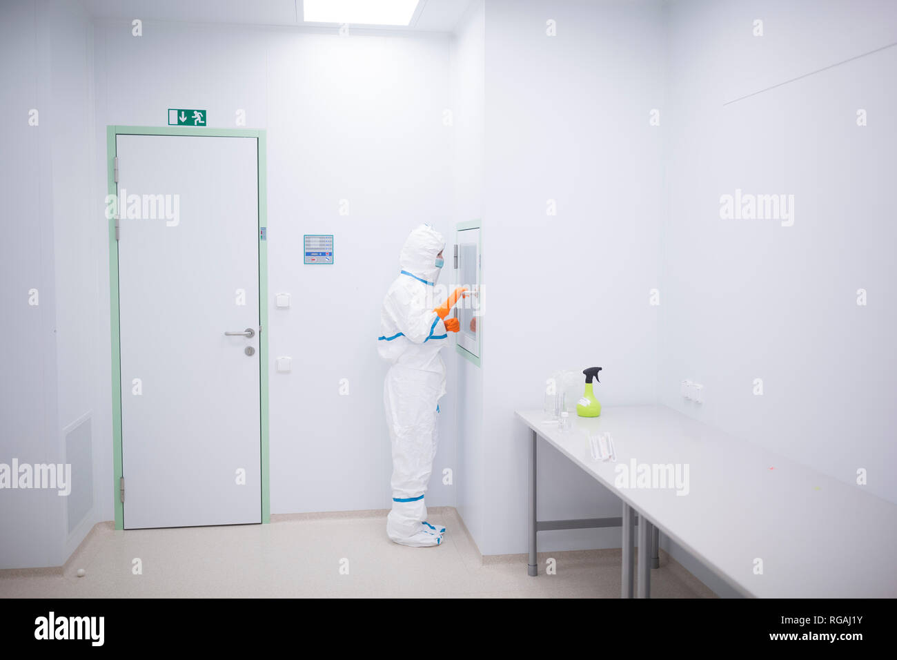 Lab technician wearing cleanroom overall at material sluice Stock Photo