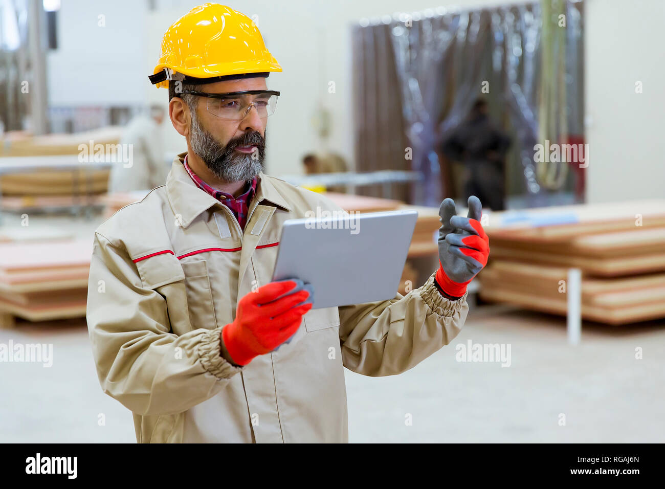Hand Some Engineering Handosme senior engineer with helmet controlling works in factory with ...