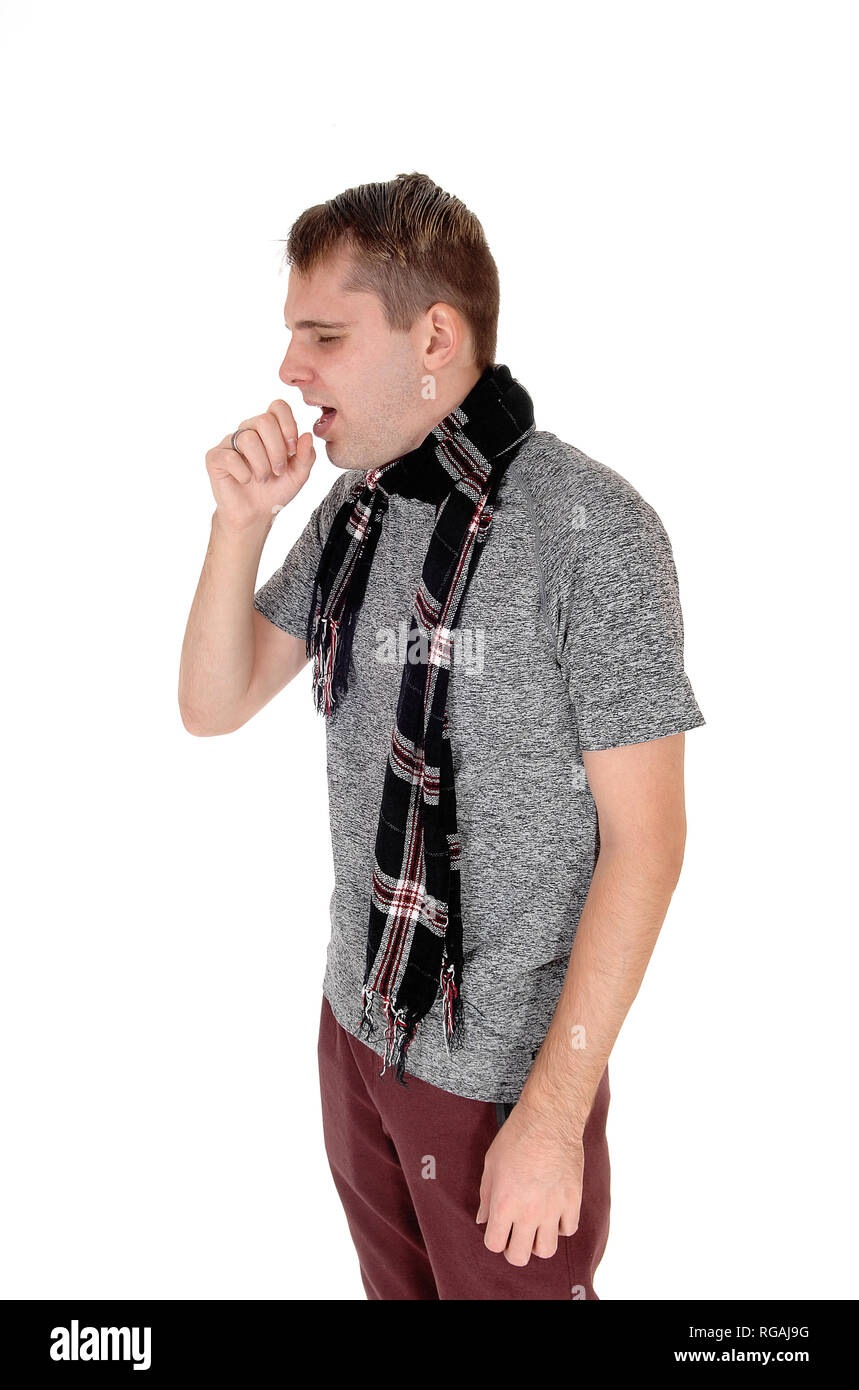 Ayoung man standing in a sweater and a scarf around his neck holding hand on his mouth and coughing, isolated for white background Stock Photo