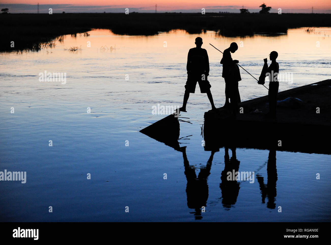 ZAMBIA Barotseland Mongu, Mulamba harbour at river Zambezi flood plain, people fishing at dawn / SAMBIA Barotseland , Stadt Mongu , Hafen Mulamba in der Flutebene des Zambezi Fluss, Menschen angeln in der Abenddaemmerung Stock Photo