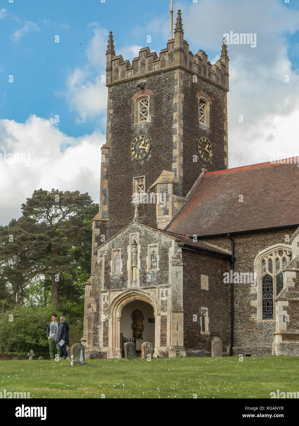Sandringham, Norfolk, UK - April 26, 2014: View of Mary Magdalene church on the sandringham estate in Nolfolk.  Shot shows tower and clock with people. Stock Photo