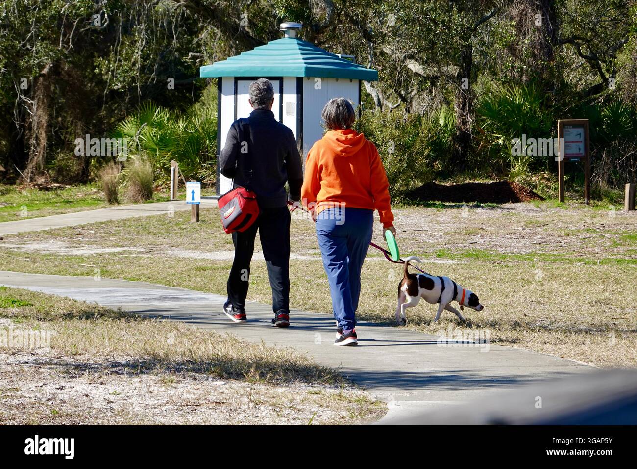Couple man woman with dog at Cemetery Point disc golf park, Cedar Key