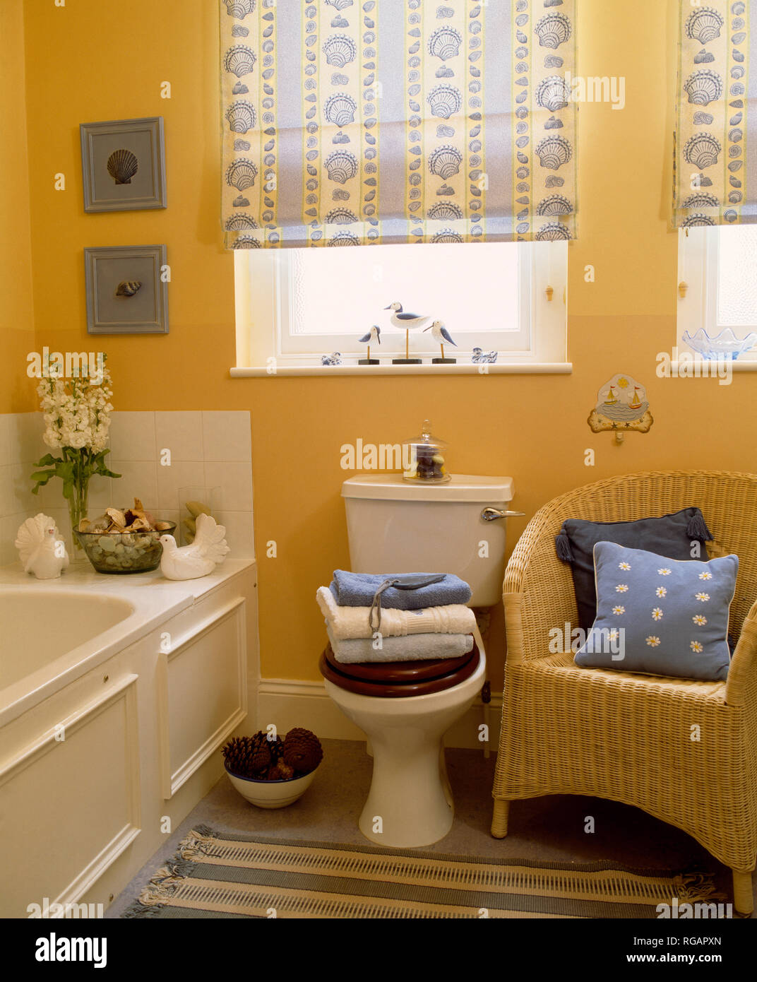Wicker armchair in yellow bathroom Stock Photo - Alamy