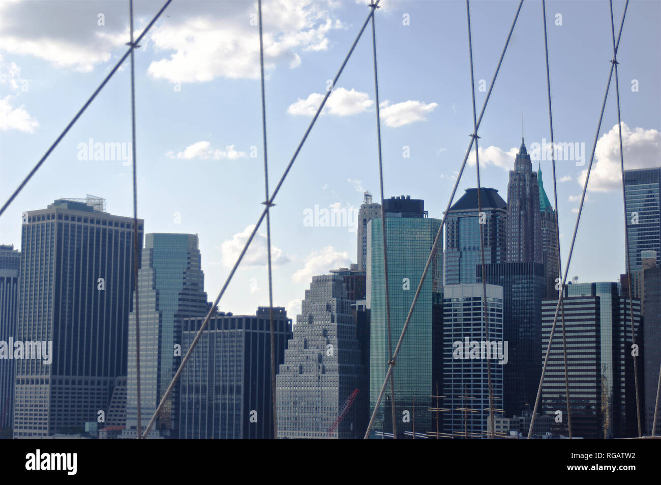 A view of lower Manhattan through the crucible cast-iron cables of the Brooklyn Bridge in New York City. Stock Photo
