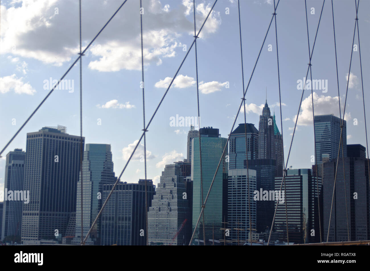 A view of lower Manhattan through the crucible cast-iron cables of the Brooklyn Bridge in New York City. Stock Photo