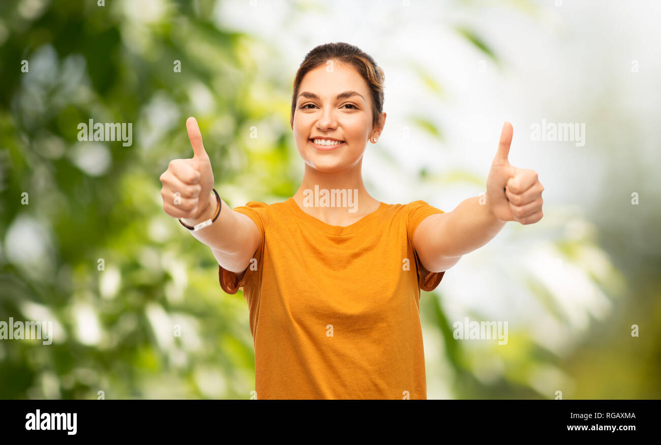 teen girl showing thumbs up over natural backgdrop Stock Photo - Alamy
