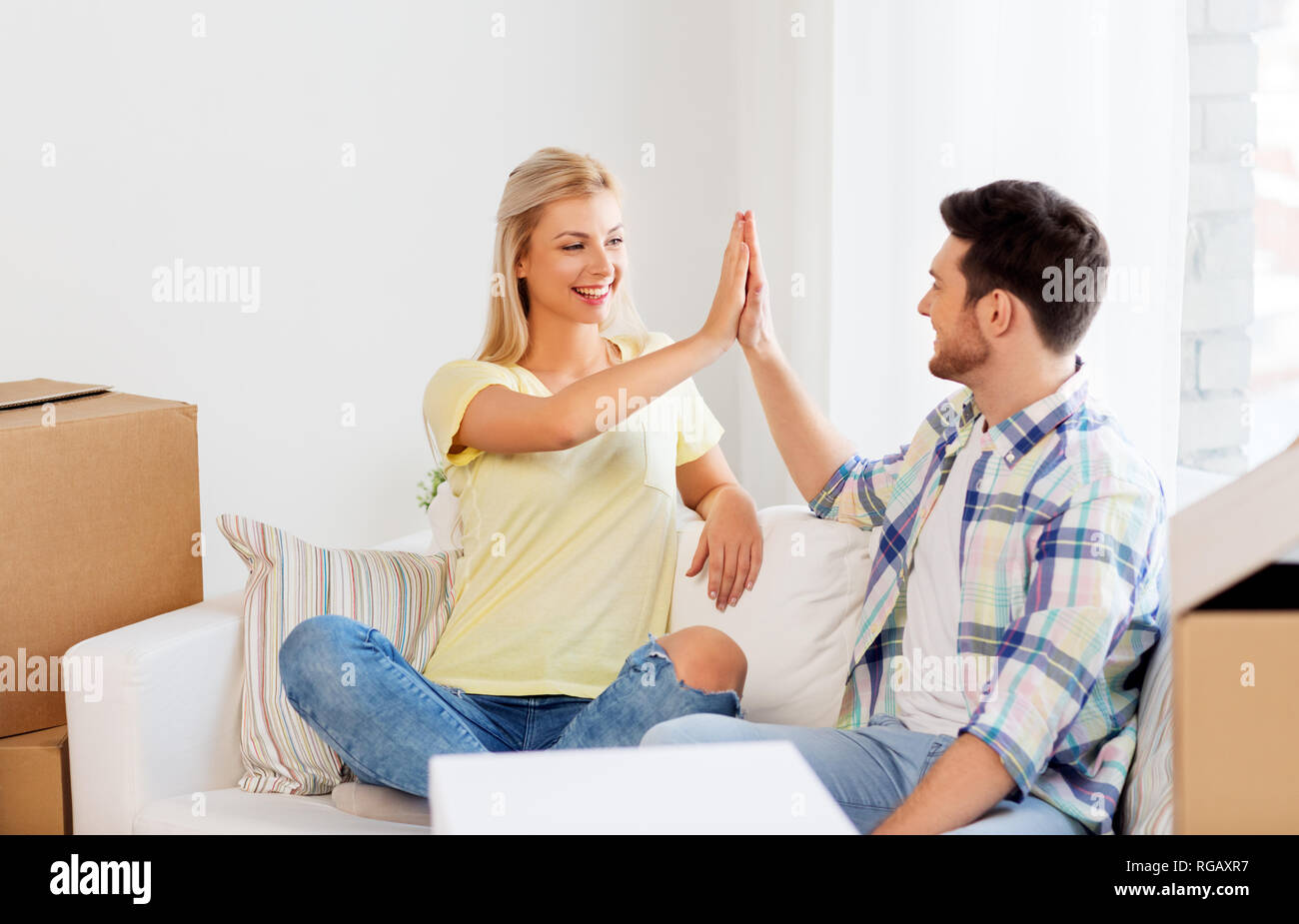 happy couple with boxes moving to new home Stock Photo - Alamy