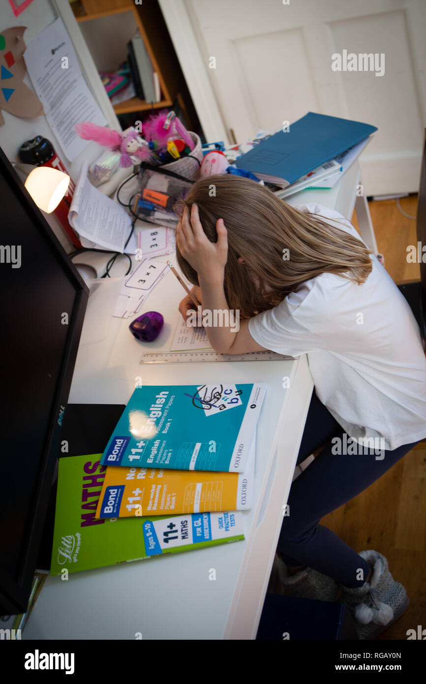 Young girl aged 10 doing her maths homework at a desk Stock Photo