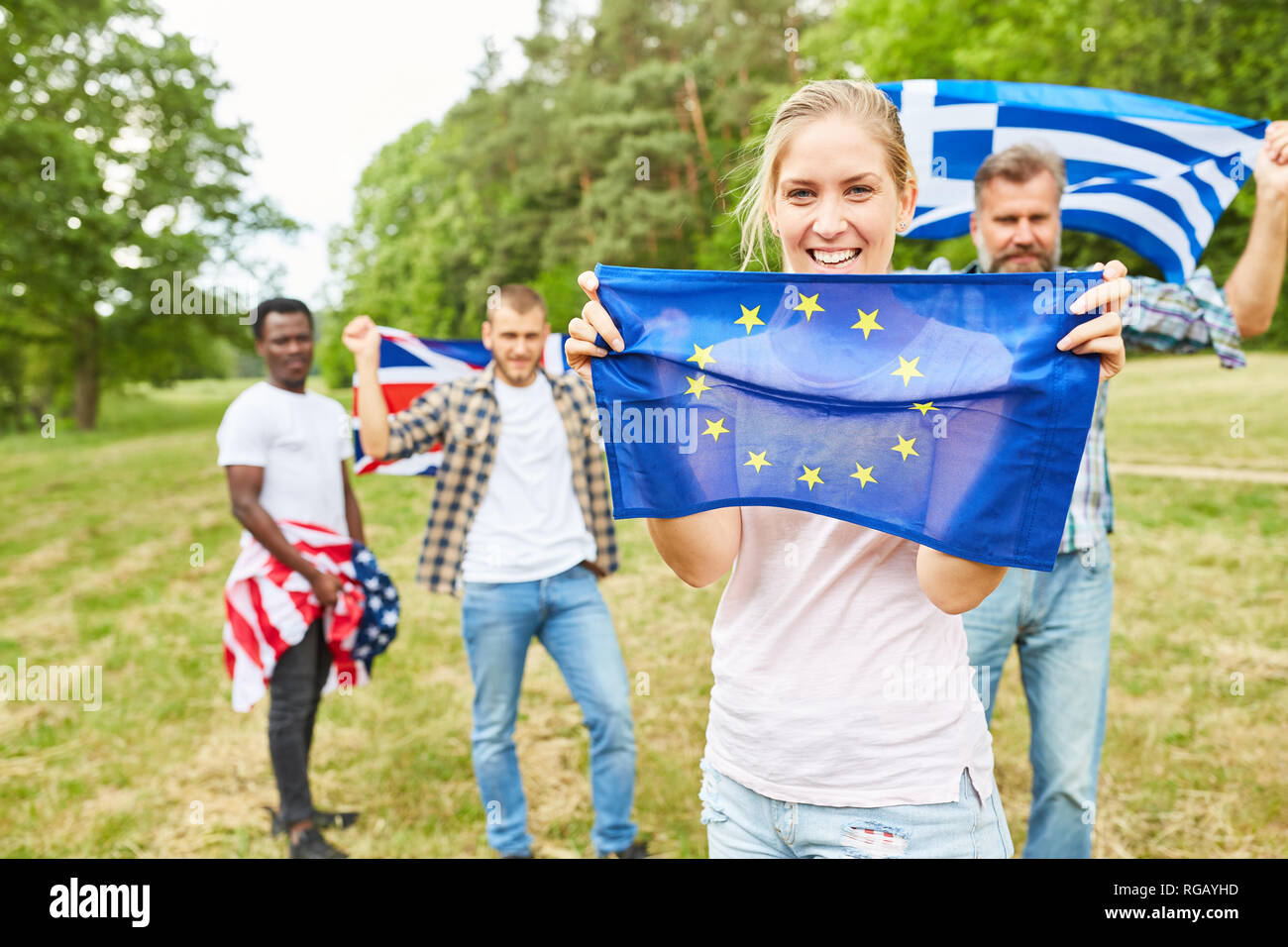 Proud young woman with EU flag in the park and students with different national flags Stock Photo