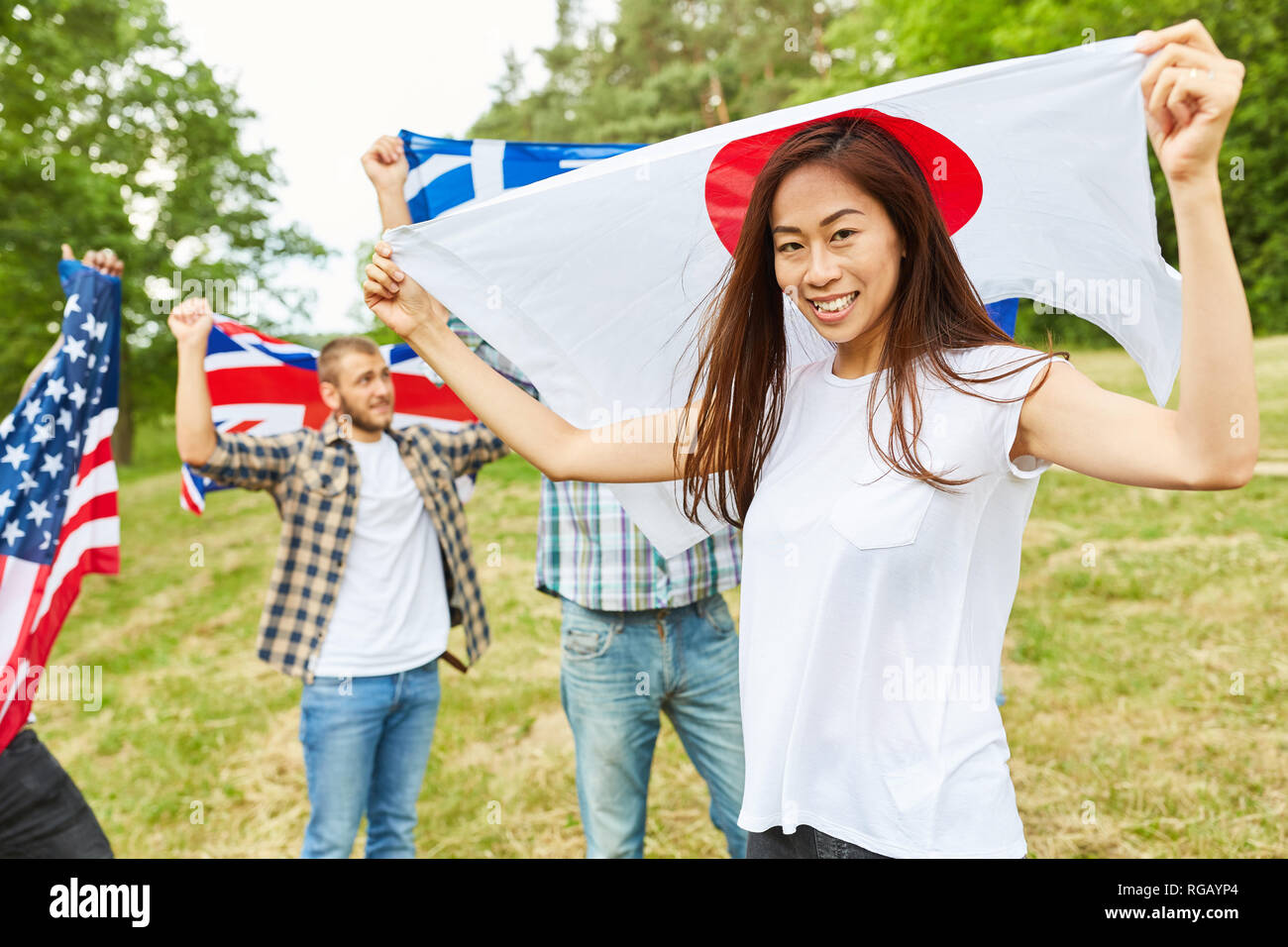 Japanese woman with national flag in the park and students with flags in the background Stock Photo