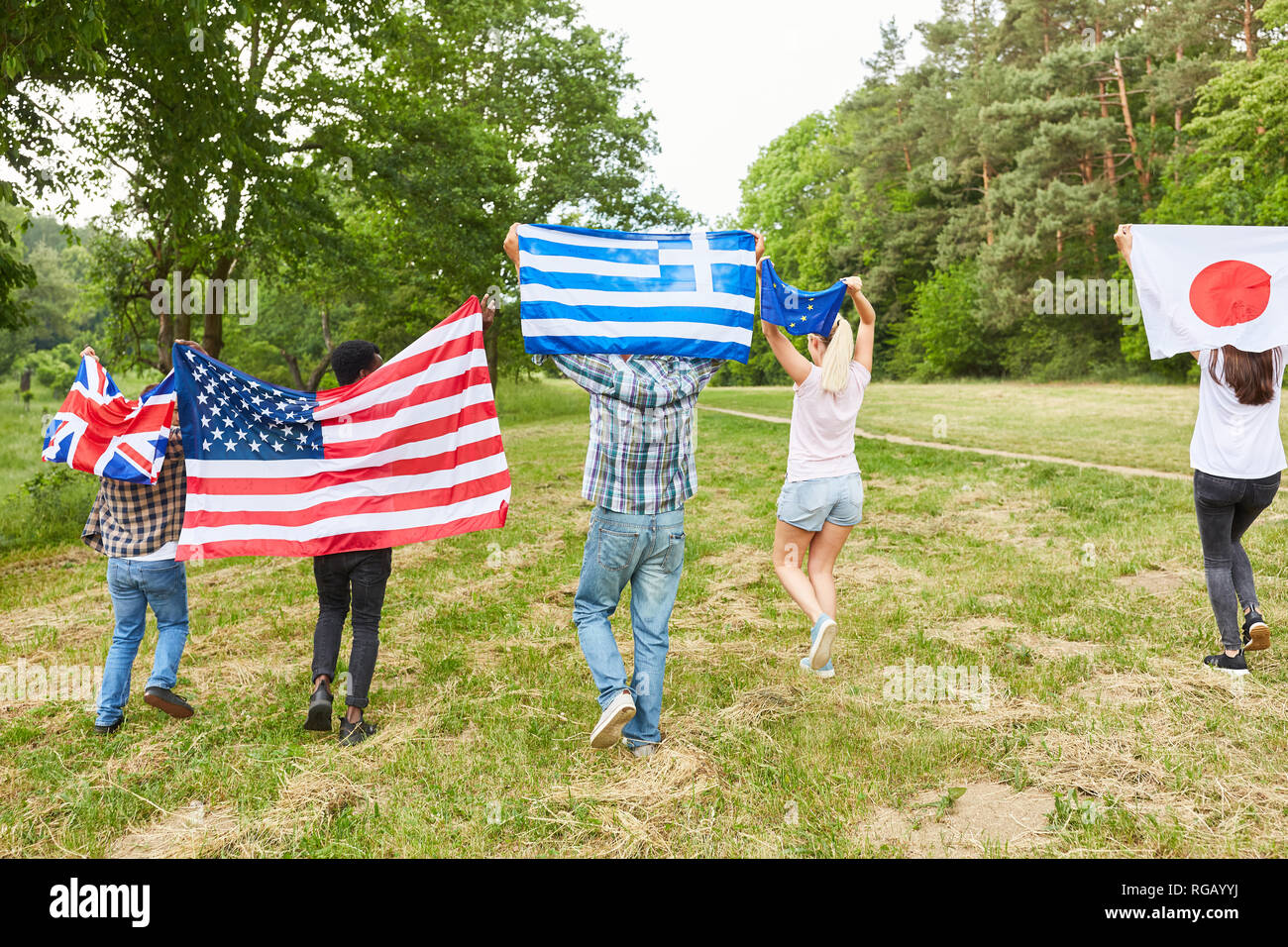 Students run with different national flags as a sign of multilateralism Stock Photo