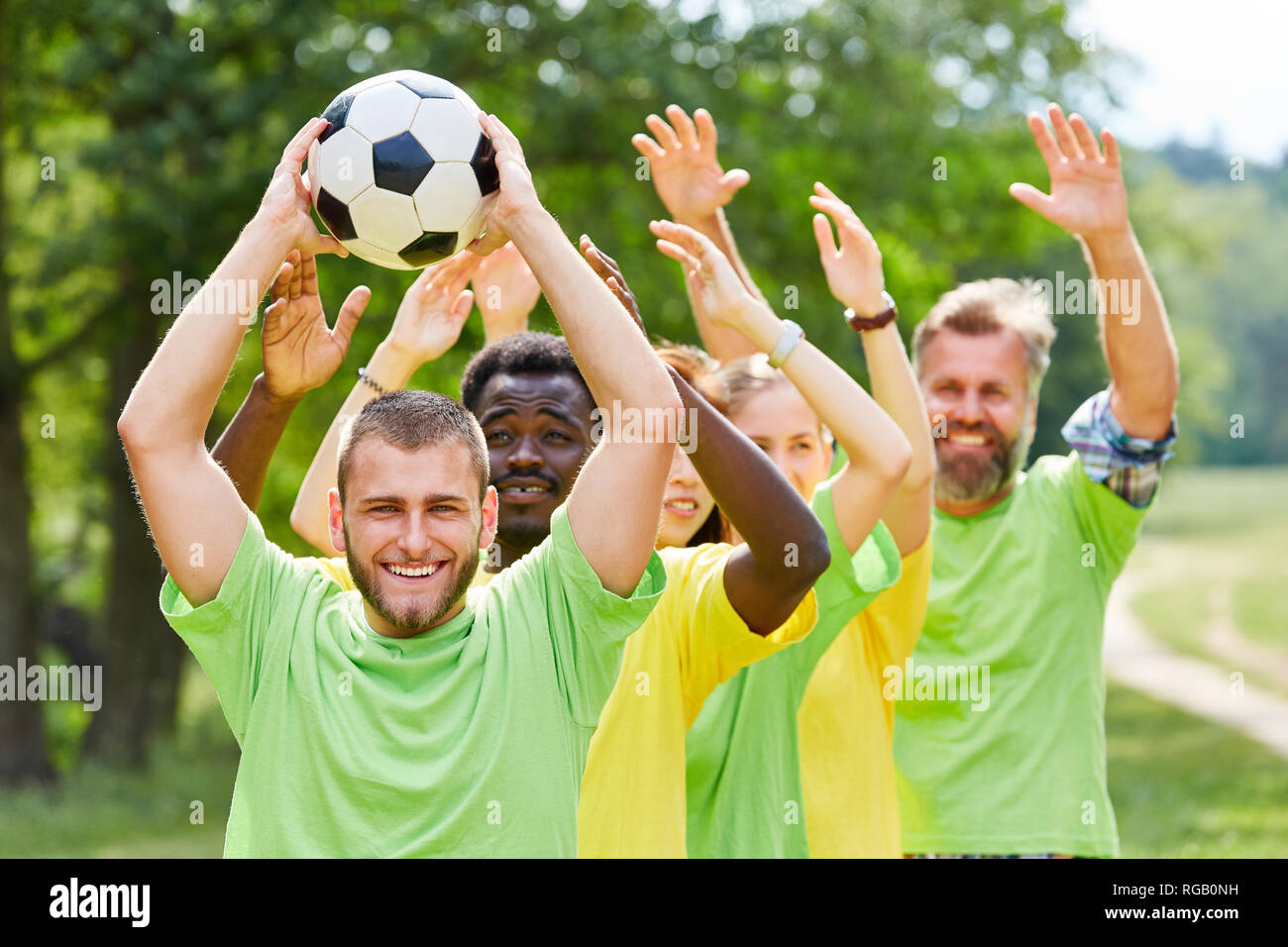 Group as a team plays with football at a teambuilding event Stock Photo
