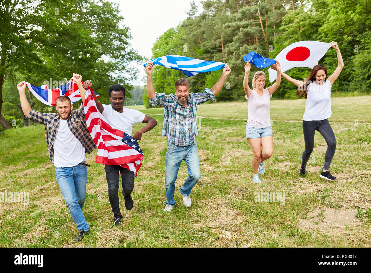 Group of students are running in the park with national flags as a sign of patriotism Stock Photo