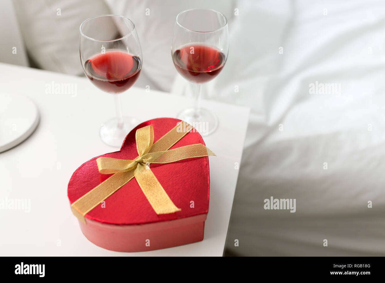 https://c8.alamy.com/comp/RGB18G/gift-and-two-glasses-of-wine-in-bedroom-at-home-RGB18G.jpg