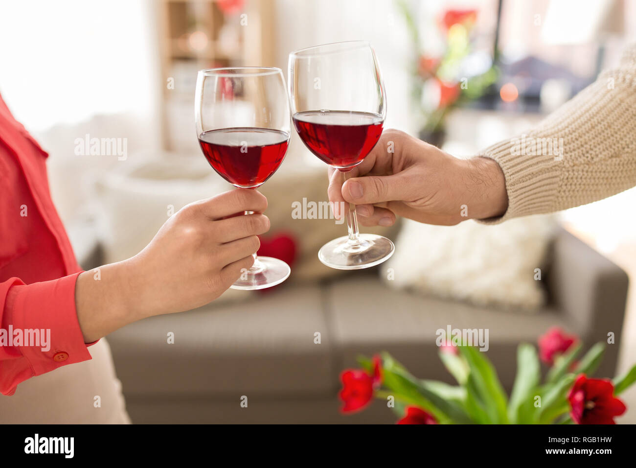 hands of couple with red wine glasses toasting Stock Photo - Alamy