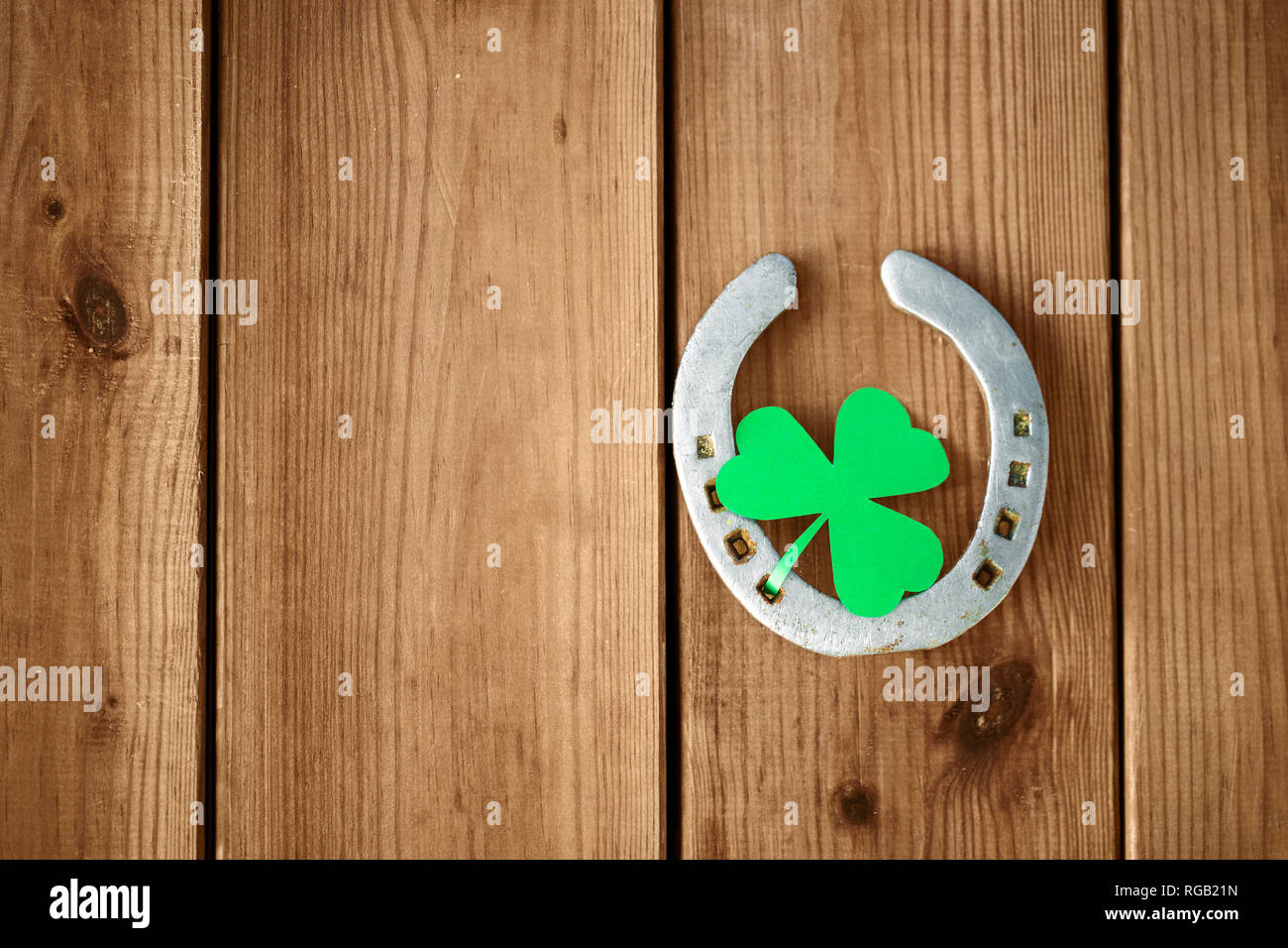 Horseshoe With Shamrock On Wooden Background Stock Photo