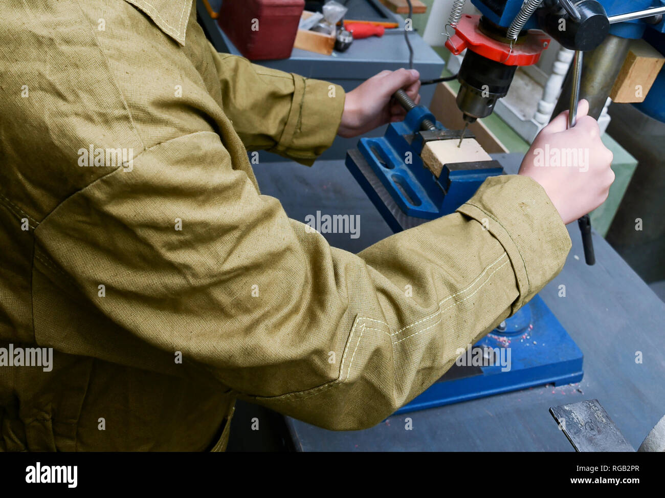 Male student using drilling machine in school workshop, vocational education at school Stock Photo