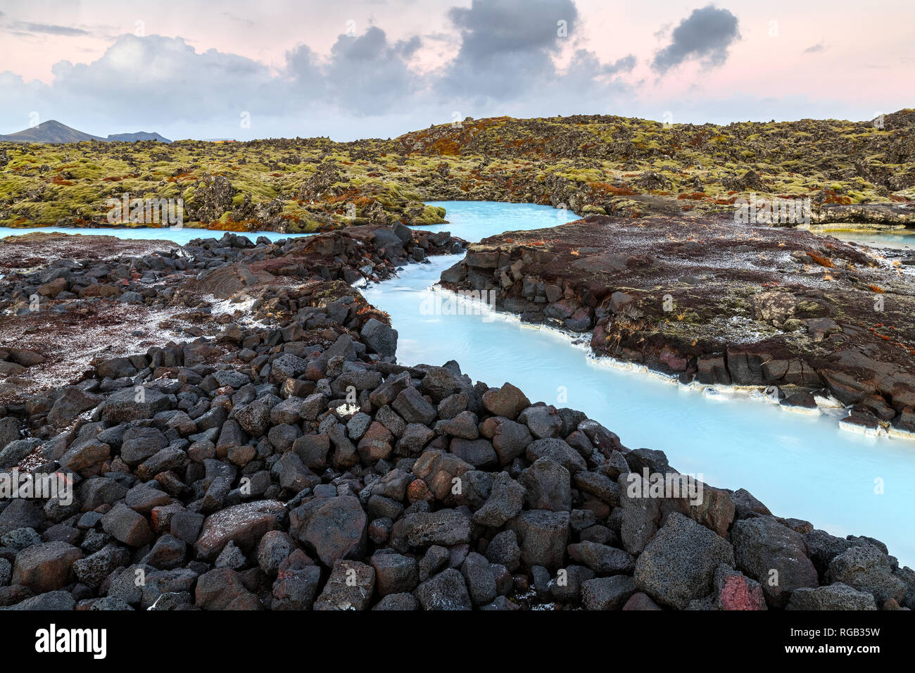 Dramatic landscape of a beautiful volcanic terrain with black volcanic rocks and turquoise water at Blue Lagoon near Grindavik in Reykjanes peninsula  Stock Photo