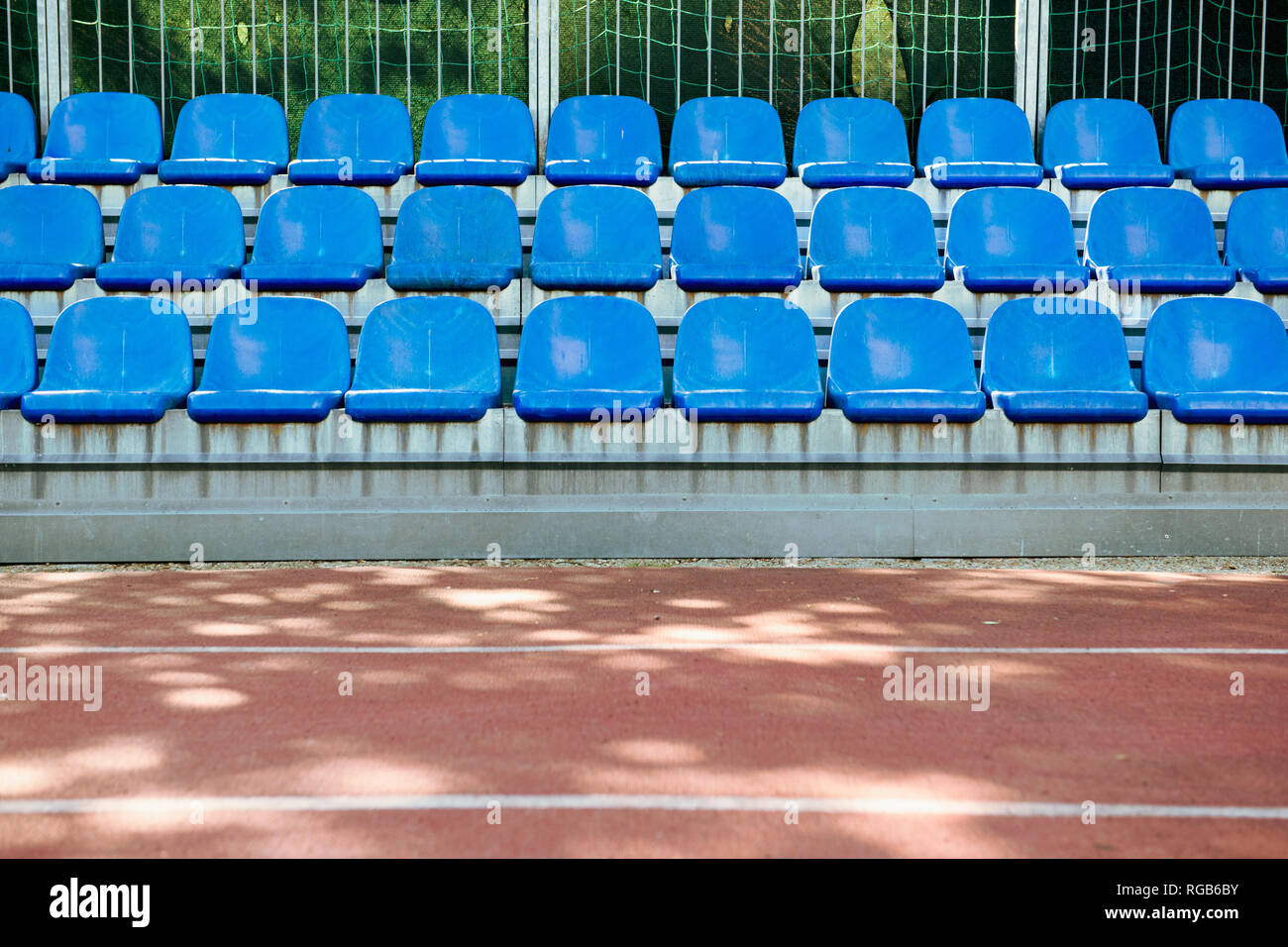 Empty blue seats in sport centre with athletic track Stock Photo