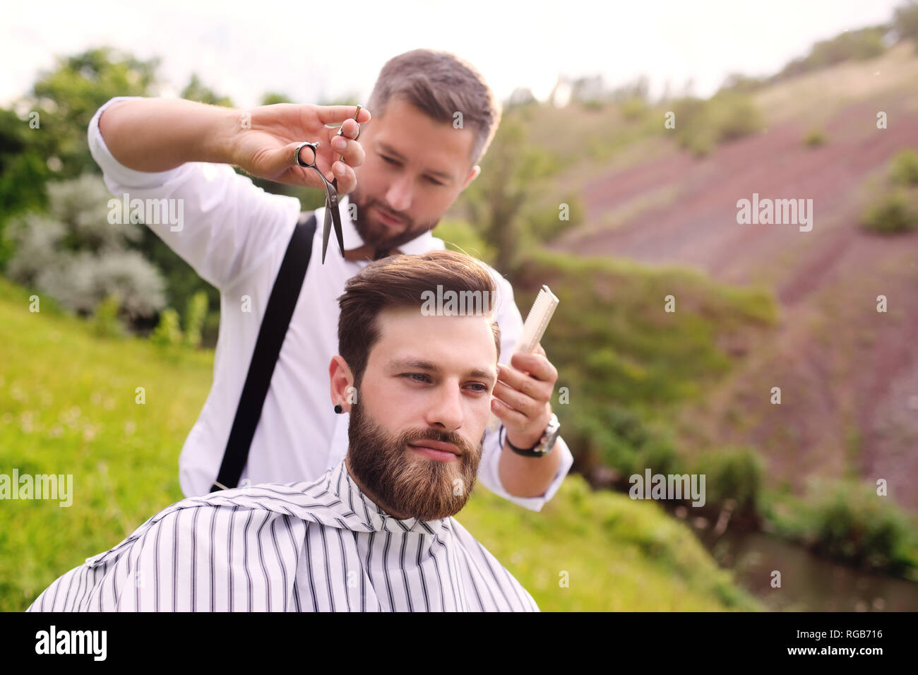 Barber does her hair and shaves the beard of the client in the Barber