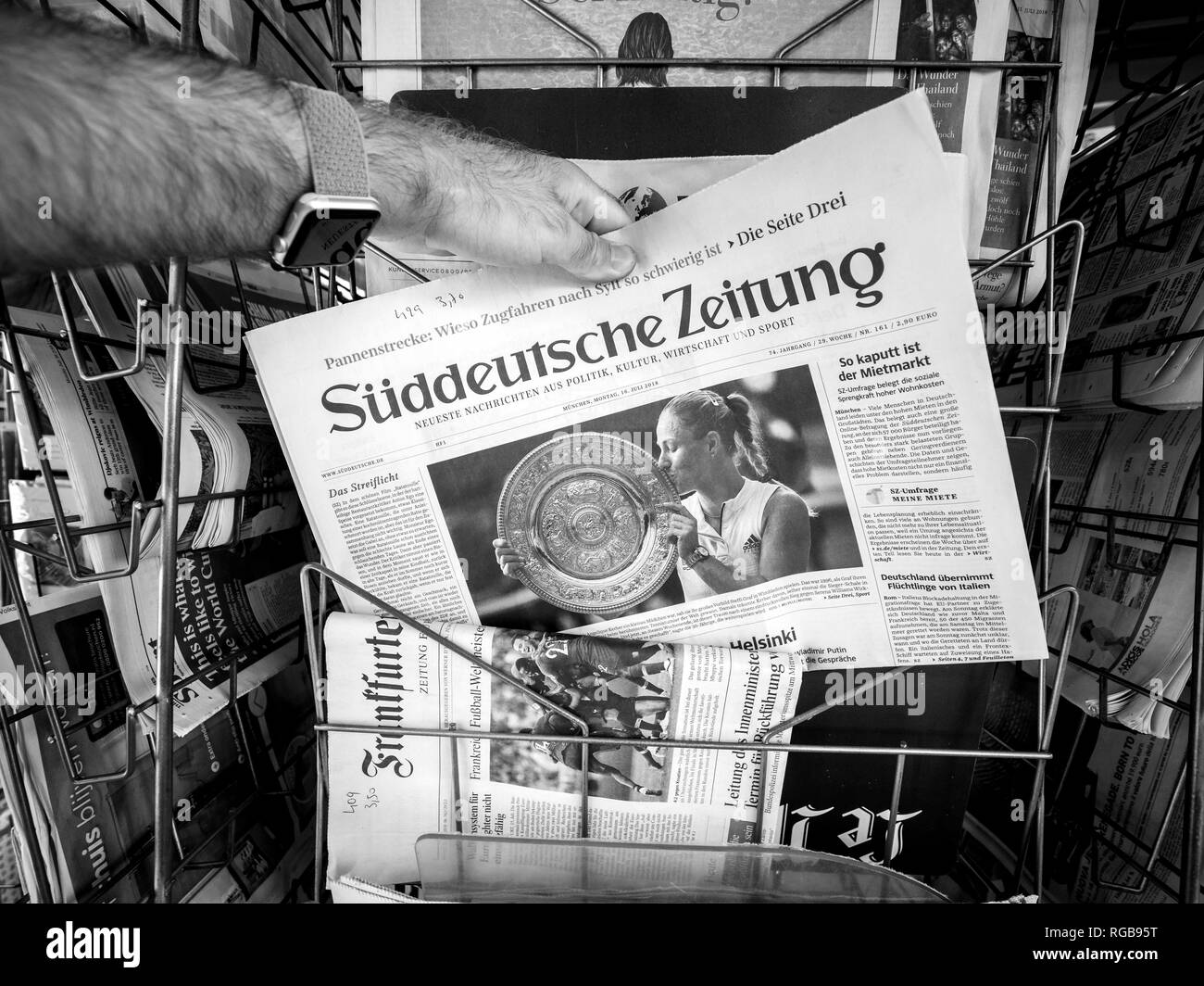 PARIS, FRANCE - JUL 16, 2018: Man buying  newspaper announcing Angelique Kerber winning tennis title in Wimbledon - black and white Stock Photo