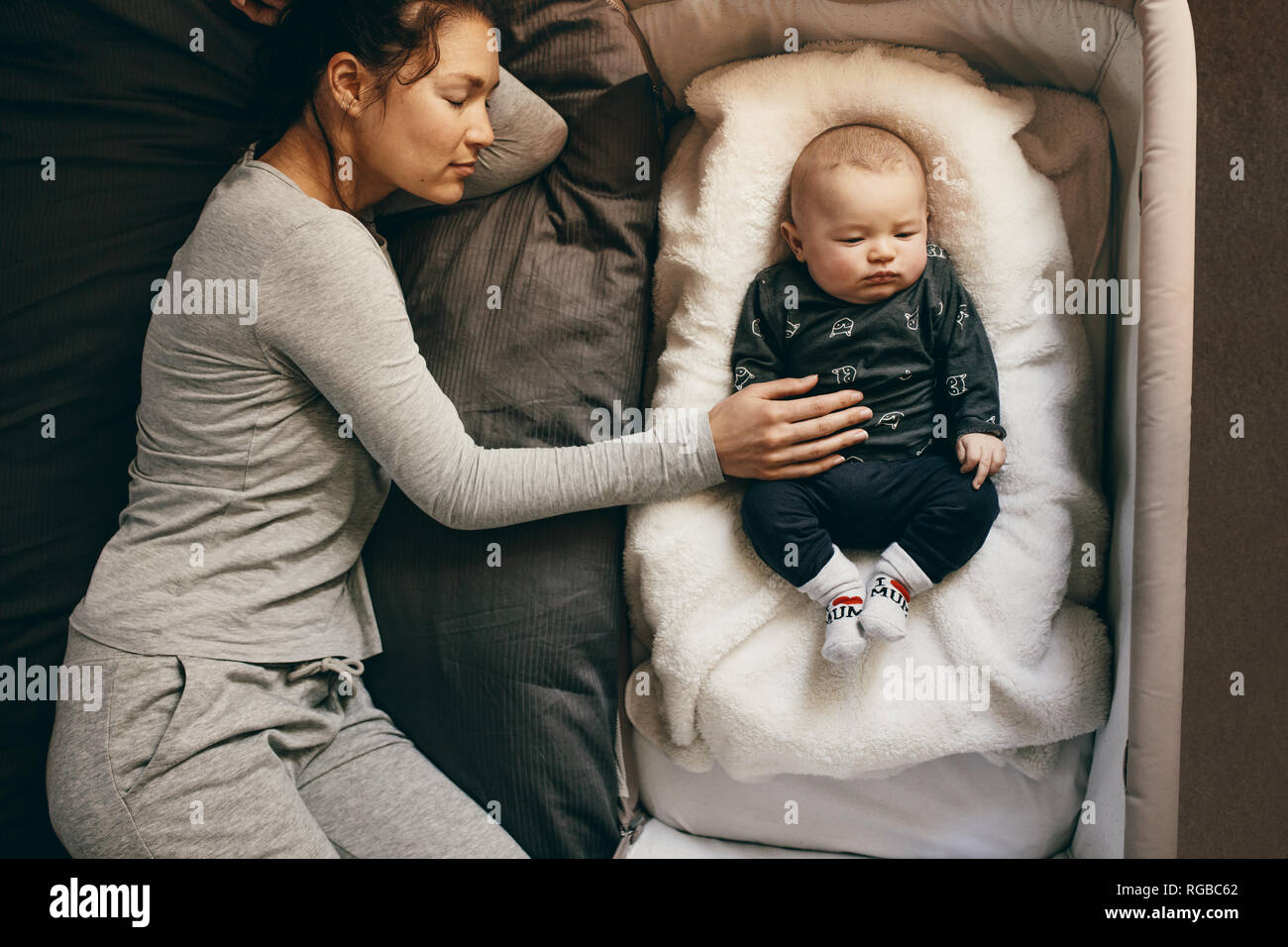 Mom sleeping with 2025 baby in crib