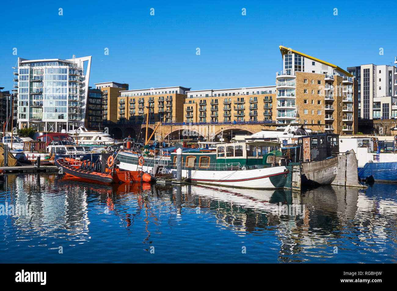 Yachts and narrowboats in Limehouse Basin, East London UK, with new apartments, on a bight sunny day Stock Photo
