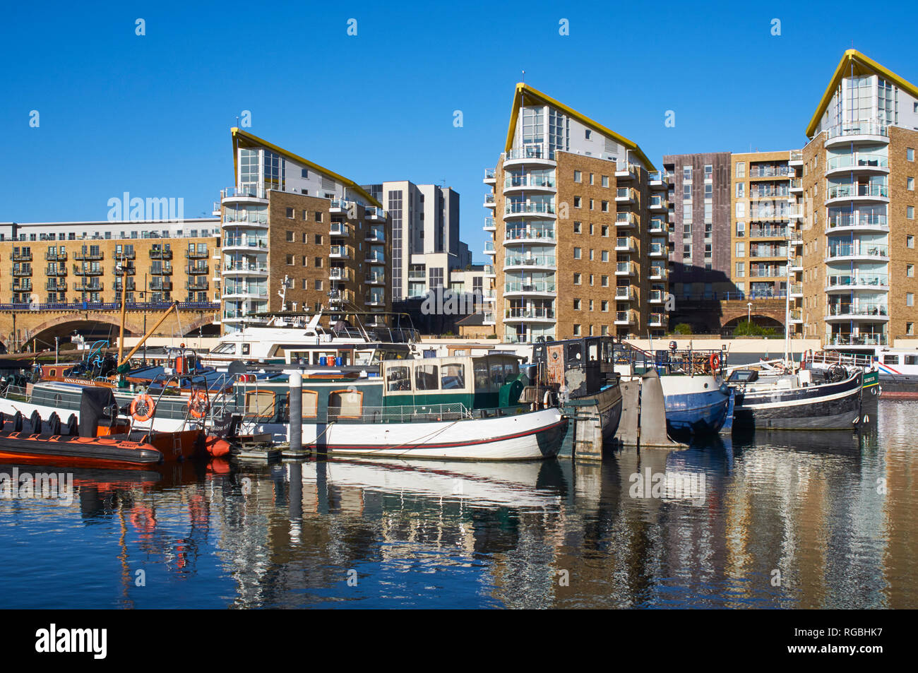 Boats moored in Limehouse Basin, East London UK, with modern apartment