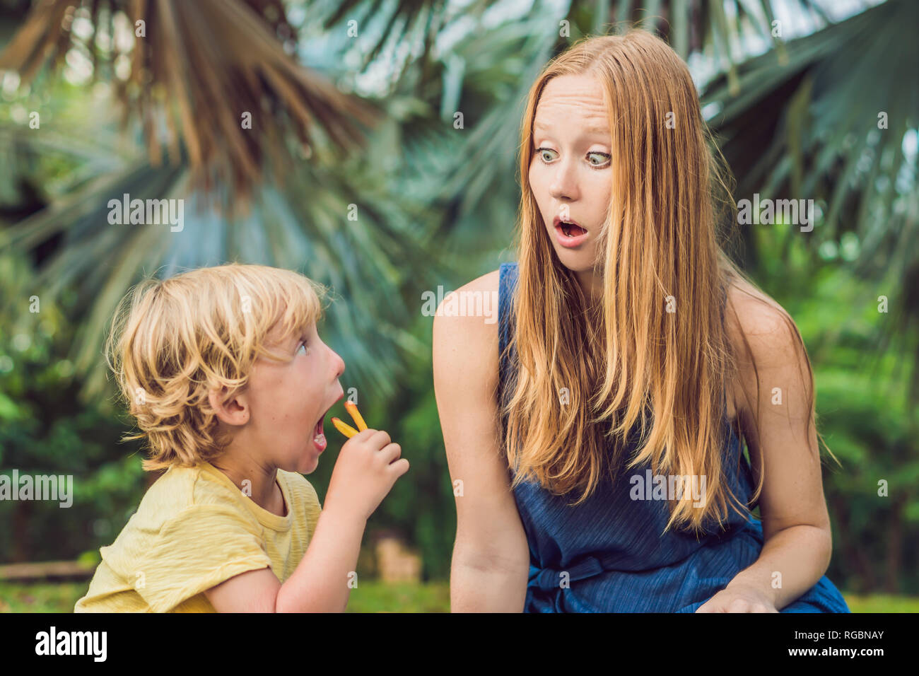 Cute healthy preschool kid boy eats french fries potatoes with ketchup with his mom. child