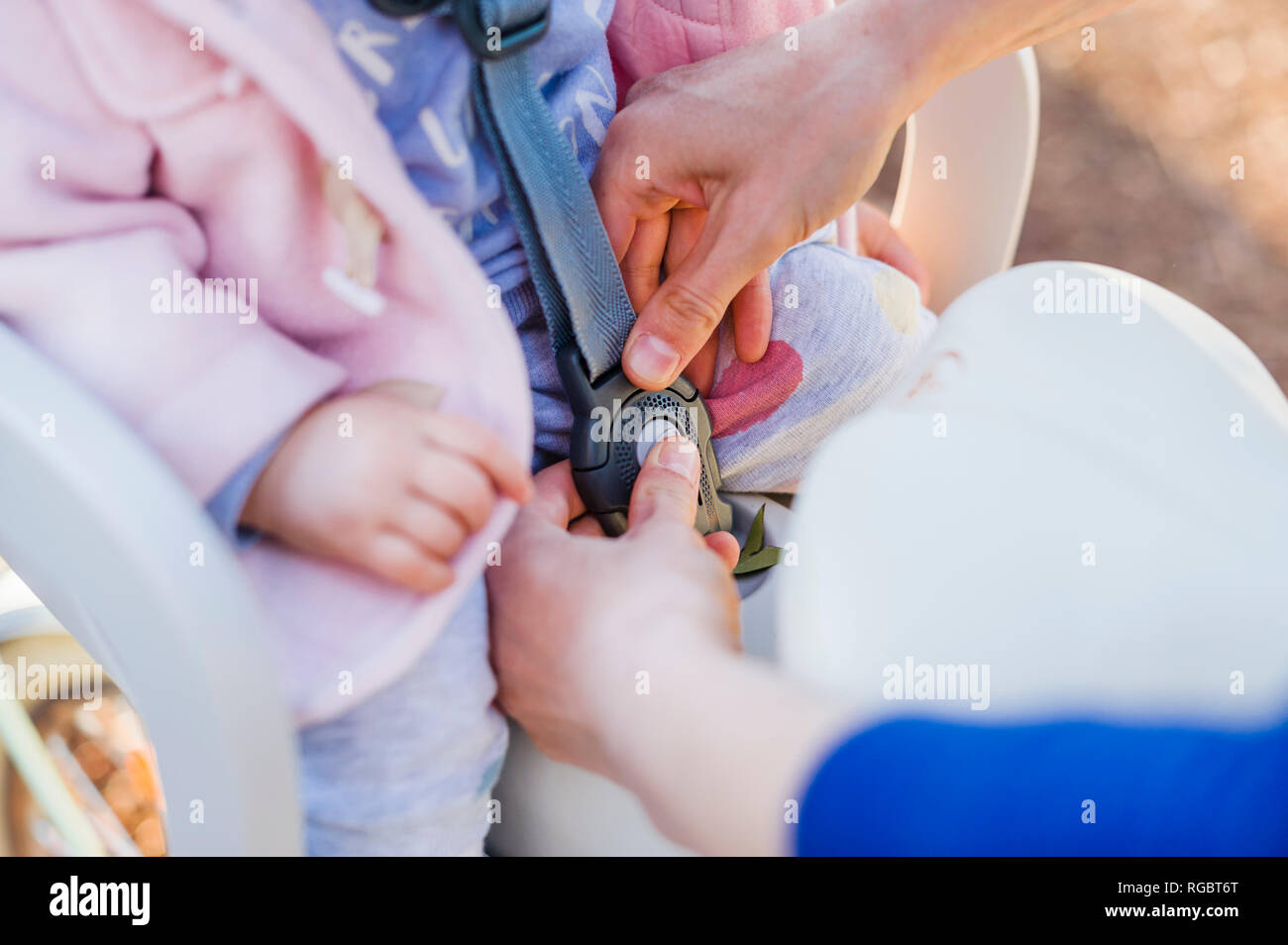 Mother fastening baby in bicycle child's seat Stock Photo