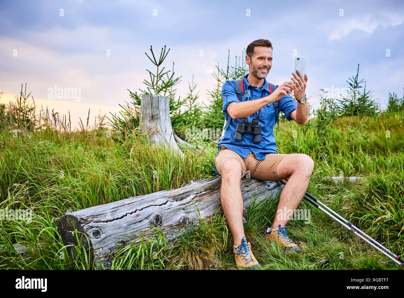 Man taking a picture with his cell phone during hiking trip Stock Photo