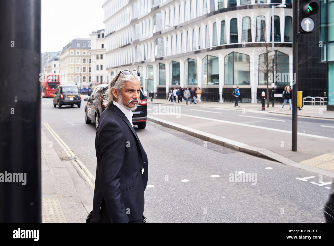 UK, London, senior businessman waiting at crosswalk in the morning Stock Photo