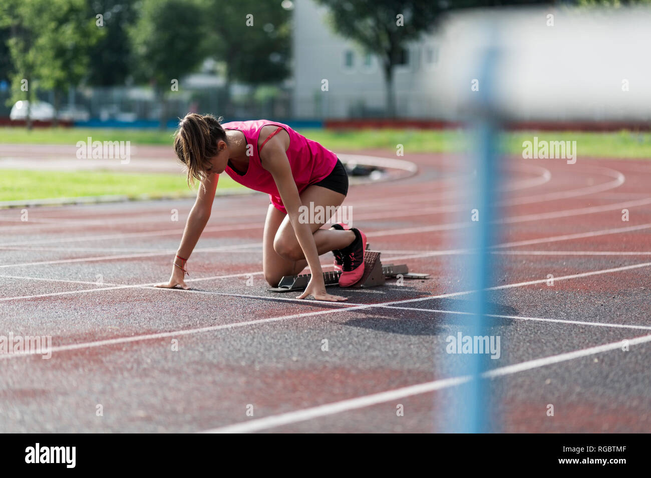 Teenage runner training start on race track Stock Photo