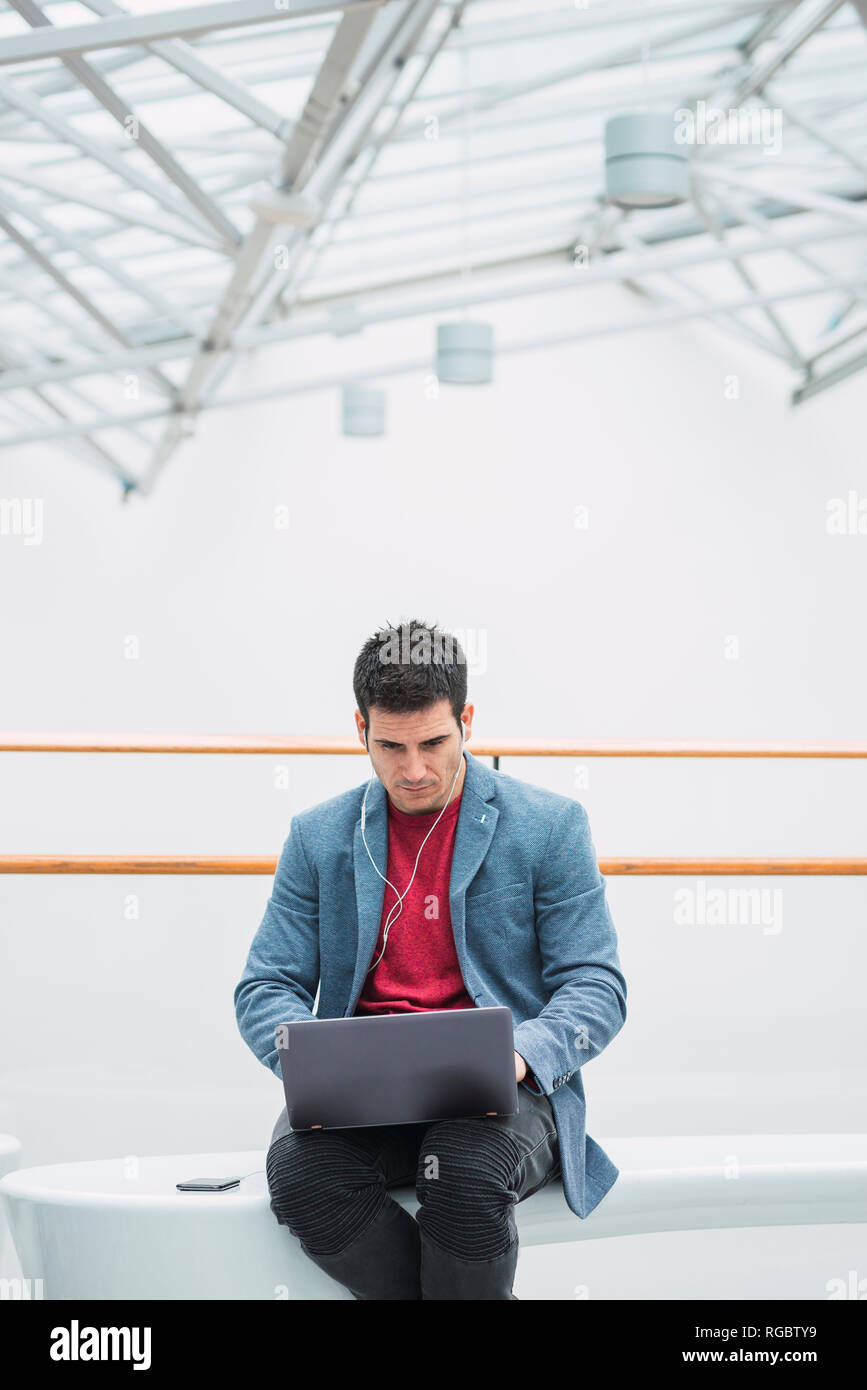 Businessman in lobby of a modern building, using Stock Photo