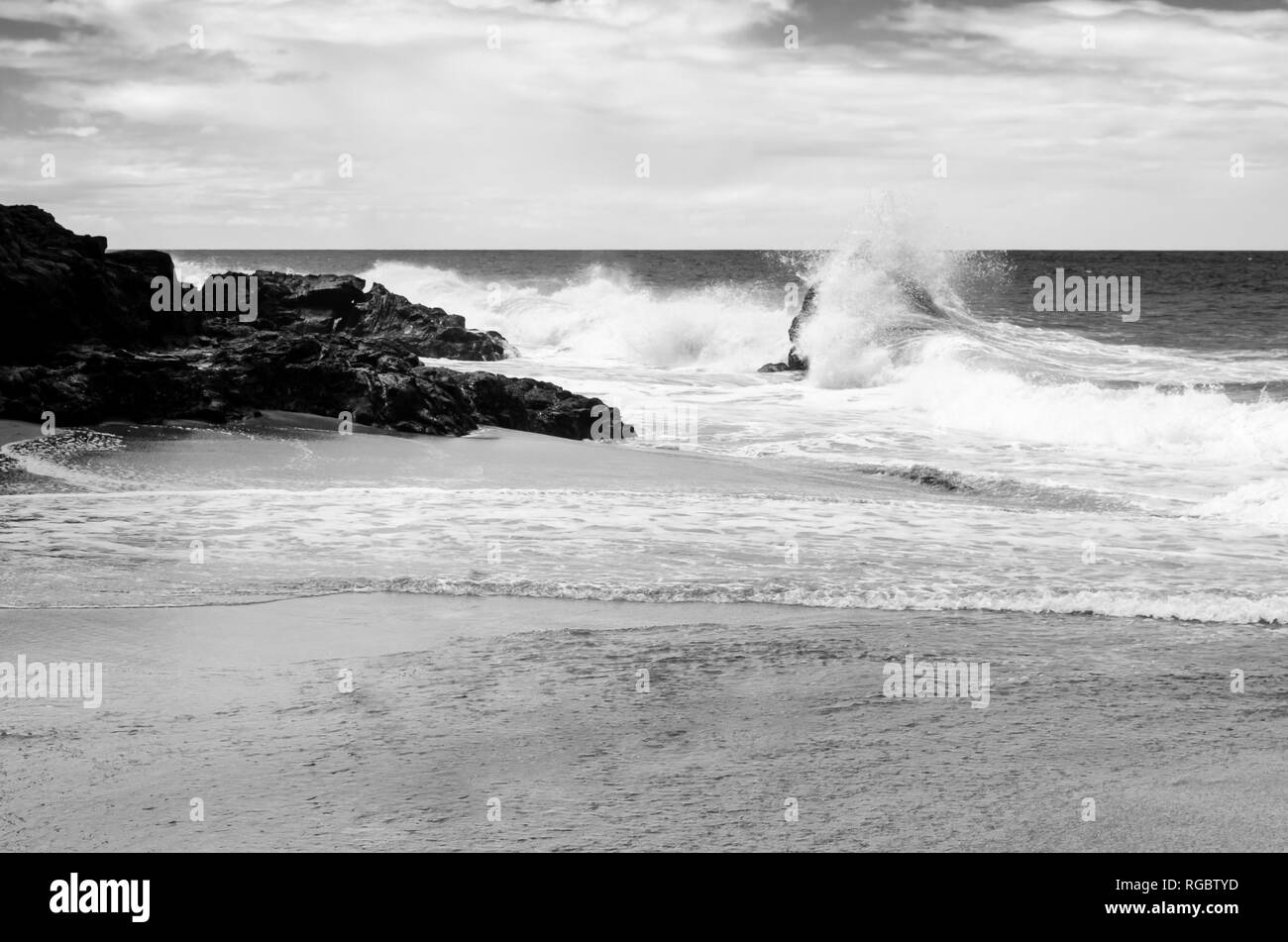 Strong black and white image of the waves beating against the rocks in ...
